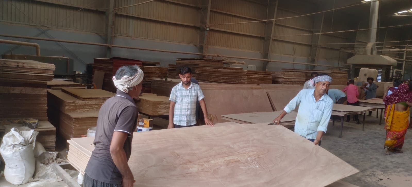 Workers inspecting plywood quality at SRS LLP